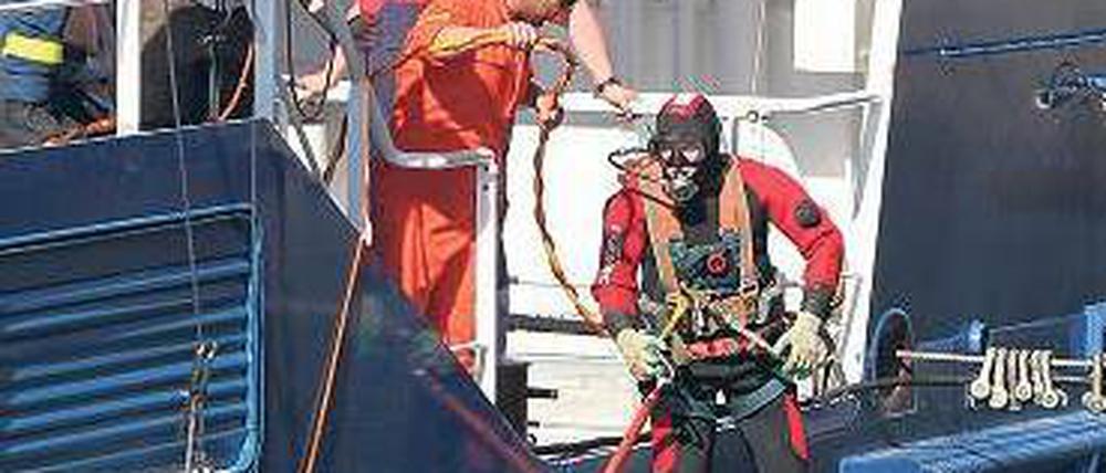 Ein Taucher inspiziert den Schaden an dem leck geschlagenen Schiff. Foto: dpa