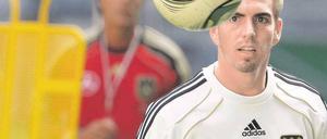 Harmlos am Ball. Philipp Lahm (im Hintergrund Bundestrainer Joachim Löw) hat aufgeschrieben, was er als junger Fußballer „selbst gern gelesen hätte“. Foto: dapd