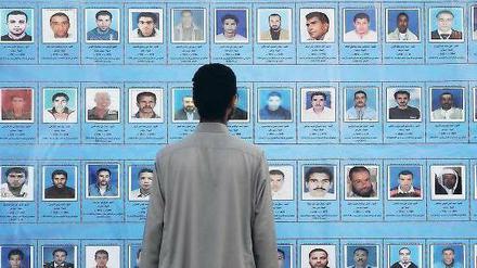 Wo sind sie? Ein Mann betrachtet Bilder von Gefallenen oder Verschollenen während des Aufstands gegen Muammar al Gaddafi. Foto: dpa