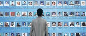 Wo sind sie? Ein Mann betrachtet Bilder von Gefallenen oder Verschollenen während des Aufstands gegen Muammar al Gaddafi. Foto: dpa