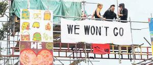 Klare Ansage. Auf einem Gerüstturm lassen Aktivisten aus dem Lager der Landfahrer die Öffentlichkeit wissen, dass sie sich nicht vertreiben lassen wollen.