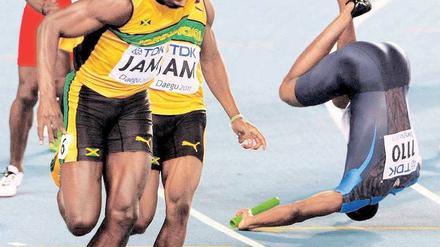 Diesmal straucheln die anderen. Während Usain Bolt (l.) den Stab korrekt von Yohan Blake übernimmt, fällt der US-Amerikaner Darvis Patton nach Gegnerkontakt. Foto: Reuters