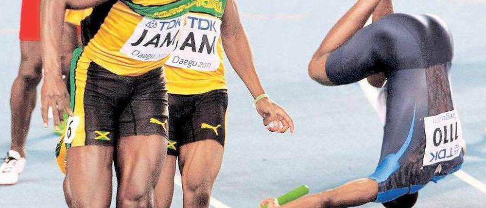Diesmal straucheln die anderen. Während Usain Bolt (l.) den Stab korrekt von Yohan Blake übernimmt, fällt der US-Amerikaner Darvis Patton nach Gegnerkontakt. Foto: Reuters