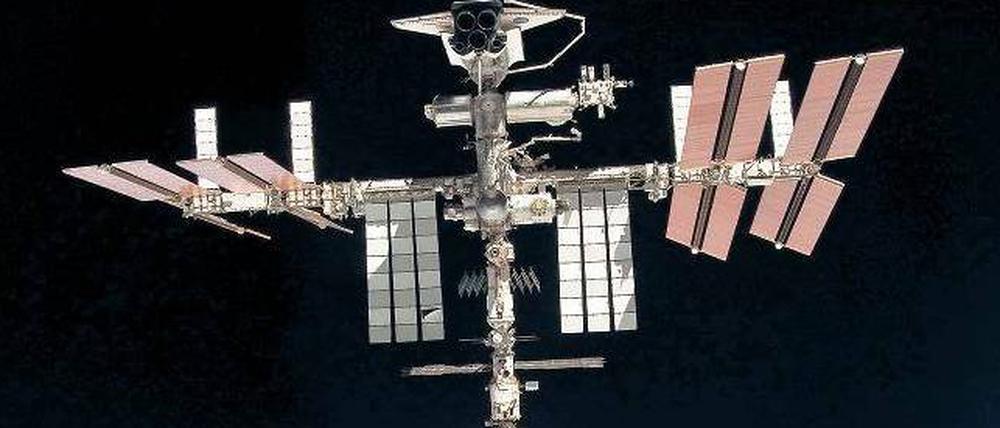 Über den Wolken. Die Raumstation (hier eine Aufnahme vom Mai 2011) rast mit 28 000 Kilometern pro Stunde um die Erde. Derzeit sind drei Russen, zwei Amerikaner und ein Japaner an Bord, die bis zum Jahresende zurückkehren müssen. Ob bis dahin neue Astronauten zur Station fliegen, ist unsicher.