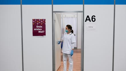 Eine Impfhelferin steht vor einer leeren Impfkabine.