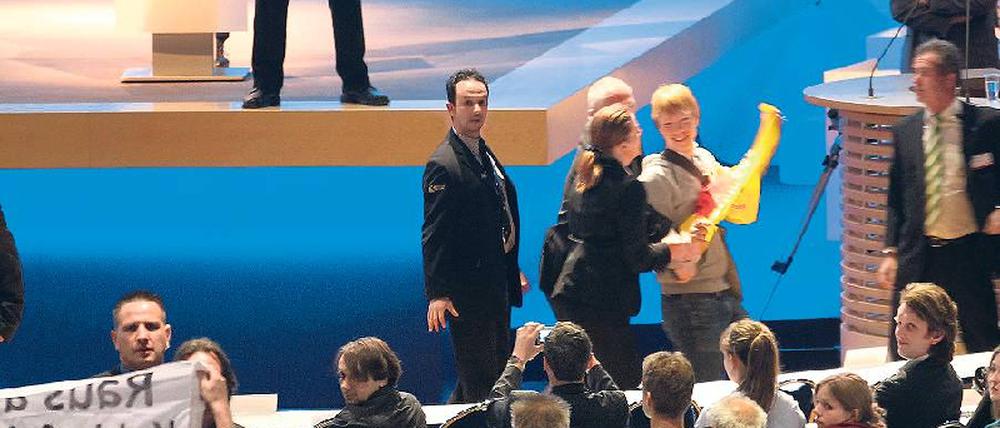 Geschützte Rede. Vorstand Jürgen Großmann wird während einer Ansprache bei der RWE-Hauptversammlung im April von Atomkraftgegnern gestört. Foto: Roland Weihrauch/dpa