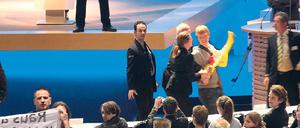 Geschützte Rede. Vorstand Jürgen Großmann wird während einer Ansprache bei der RWE-Hauptversammlung im April von Atomkraftgegnern gestört. Foto: Roland Weihrauch/dpa