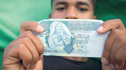 Bargeld lacht. Gaddafis Antlitz ziert einige Dinar-Scheine in Libyen. Der Diktator selbst investierte lieber in Dollar und Euro. Foto: Reuters