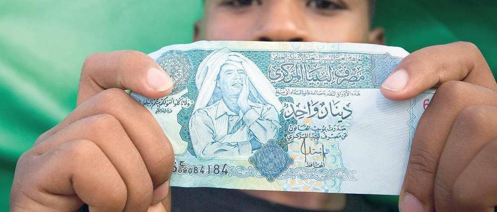 Bargeld lacht. Gaddafis Antlitz ziert einige Dinar-Scheine in Libyen. Der Diktator selbst investierte lieber in Dollar und Euro. Foto: Reuters