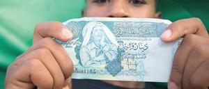 Bargeld lacht. Gaddafis Antlitz ziert einige Dinar-Scheine in Libyen. Der Diktator selbst investierte lieber in Dollar und Euro. Foto: Reuters