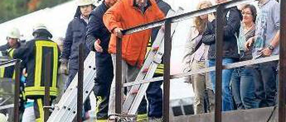 Feuerwehrleute helfen Reisenden, sich in Sicherheit zu bringen. Foto: dpa