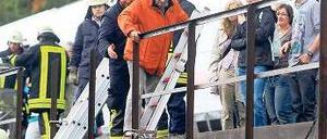 Feuerwehrleute helfen Reisenden, sich in Sicherheit zu bringen. Foto: dpa