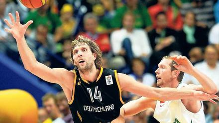 Nicht immer auf Ballhöhe. Dirk Nowitzki (li.) und Gegenspieler Darius Songaila. Foto: dpa