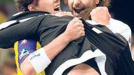 Willkommen im Team. Johannes Sellin (l.) feiert nach der Partie gegen Magdeburg mit Torhüter Silvio Heinevetter (r.). Foto: dapd