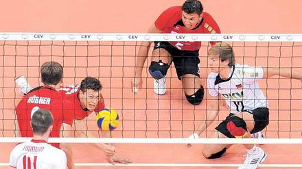 Noch nicht geschlagen. Die deutschen Volleyballer (hinter dem Netz) können aber nur durch einen Qualifikations-Marathon nach London kommen. Foto: dpa