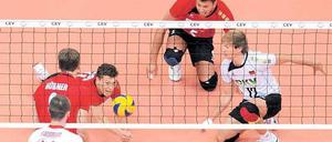 Noch nicht geschlagen. Die deutschen Volleyballer (hinter dem Netz) können aber nur durch einen Qualifikations-Marathon nach London kommen. Foto: dpa