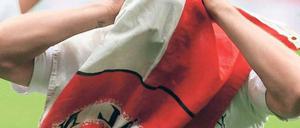 Das Gesicht des Vereins. Lukas Podolski jubelte nach dem Sieg in Leverkusen hinter einer Vereinsfahne – als wolle er allen klar machen, dass der 1. FC Köln nicht nur aus ihm selbst besteht. Zuvor hatte der Nationalspieler zwei Tore erzielt. Foto: dapd