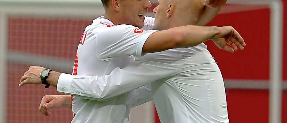 Matchwinner Lukas Podolski (l.) umarmte nach dem rheinischen Derby seinen Trainer Stale Solbakken, der nach der Kritik der letzten Wochen nun erstmal in Ruhe weiterarbeiten kann.