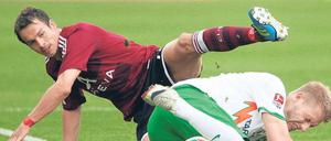 Nürnberger Durcheinander. Feulner (l.) und Hunt suchen den Ball, später erschweren Regengüsse das Spielgeschehen. Foto: dpa