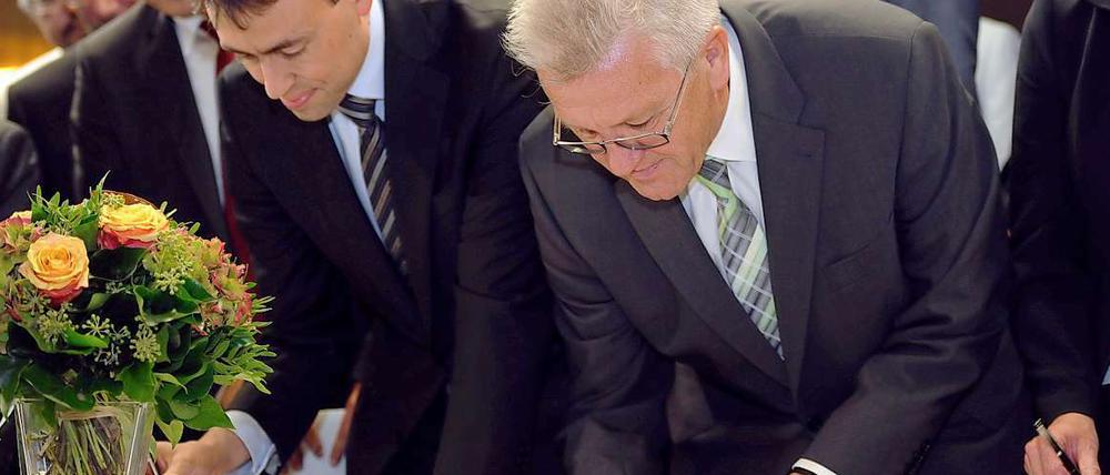 Schwarz auf Weiß. Nils Schmid (SPD) und Winfried Kretschmann (Bündnis 90/Die Grünen), unterschreiben den Antrag zur Volksabstimmung. 