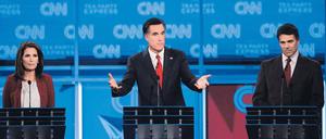 Drei im Rennen. Michele Bachmann, Anführerin des erzkonservativen Tea-Party-Flügels im Repräsentantenhaus (links), und der texanische Gouverneur Rick Perry (rechts) in einer Fernsehdebatte mit Mitt Romney, dem Ex-Gouverneur von Massachusetts. Alle drei wollen republikanischer Präsidentschaftskandidat werden. 