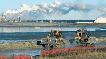 Zerstörte Landschaft. Bagger transportieren Ölsand in der Nähe von Fort McMurray in der kanadischen Provinz Alberta. Foto: AFP