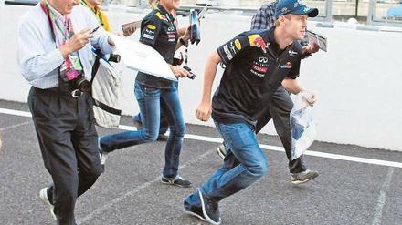 Auto vergessen? Sebastian Vettel flüchtet in Suzuka vor der Zuneigung der japanischen Formel-1-Fans. Foto: dpa