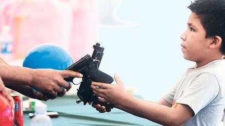 Ein Junge übergibt einem Polizisten zwei Schusswaffen – und bekommt einen Ball dafür. In der Stadt Monterrey versuchen die Behörden, der ausufernden Gewalt Einhalt zu gebieten. 40 000 Menschen starben bisher in Mexikos Drogenkrieg. 
