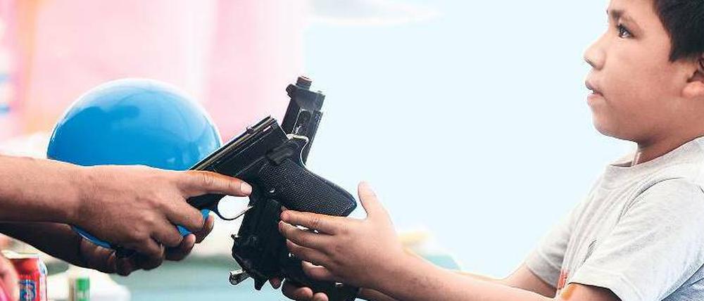 Ein Junge übergibt einem Polizisten zwei Schusswaffen – und bekommt einen Ball dafür. In der Stadt Monterrey versuchen die Behörden, der ausufernden Gewalt Einhalt zu gebieten. 40 000 Menschen starben bisher in Mexikos Drogenkrieg. 