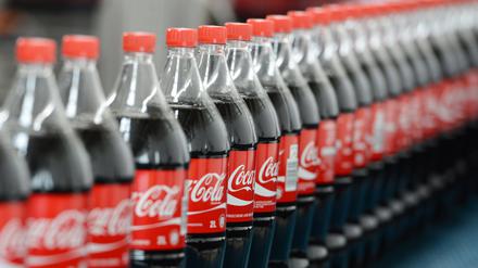 Getränkeflaschen von Coca-Cola auf einem Transportband. 