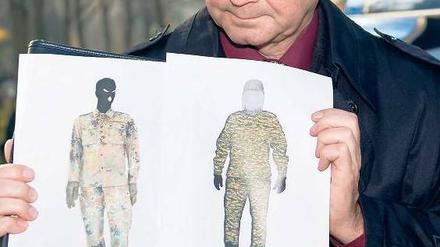 Gesichtslos. Profis wissen, dass Zeugen uniformierte Menschen nicht beschreiben können. Alle achteten auf den Tarnanzug, niemand aufs Gesicht. Ein Polizist zeigt die Phantombilder des mutmaßlichen Täters von Bad Saarow. 