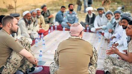 So sieht die Bundeswehr sich lieber. Deutsche Isaf-Soldaten westlich von Kundus während einer „Schura“ (Ratsversammlung) mit afghanischen Bürgern im September. Der Angriff zwei Jahre zuvor kostete aber gerade Zivilisten das Leben. Ihre Interessen werden auf dem Bonner Gipfel diese Woche nicht zuletzt durch NGOs vertreten. Foto: Sascha Schuermann/dapd