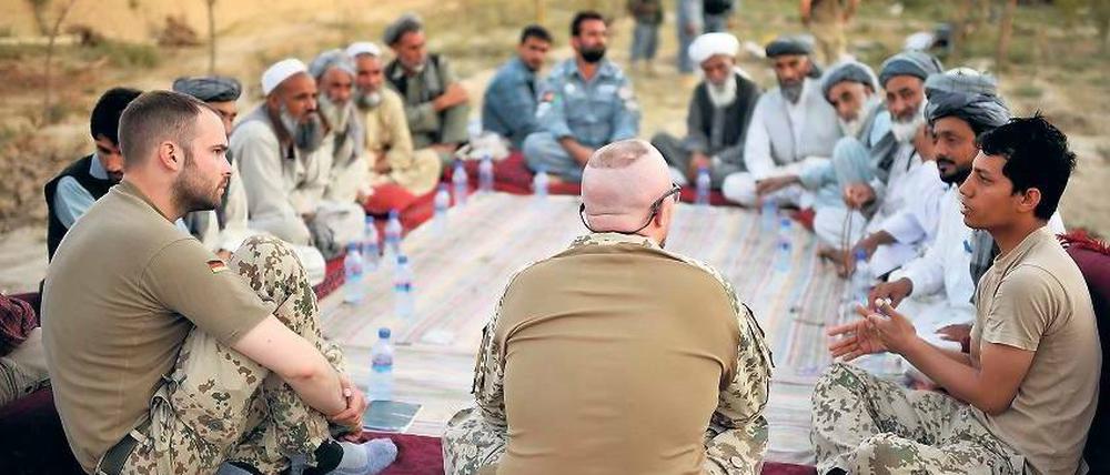 So sieht die Bundeswehr sich lieber. Deutsche Isaf-Soldaten westlich von Kundus während einer „Schura“ (Ratsversammlung) mit afghanischen Bürgern im September. Der Angriff zwei Jahre zuvor kostete aber gerade Zivilisten das Leben. Ihre Interessen werden auf dem Bonner Gipfel diese Woche nicht zuletzt durch NGOs vertreten. Foto: Sascha Schuermann/dapd