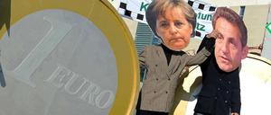 Zerrbilder aus Pappmaché: Im Oktober 2011 stehen Demonstranten mit Merkel- und Sarkozy-Masken vor dem Berliner Kanzleramt.