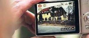 Spur des Schreckens. Ein Passant fotografiert das zerstörte Haus in der Zwickauer Frühlingsstraße, in dem das sogenannte „Neonazi-Trio“ gewohnt hatte. Foto: Arno Burgi/dpa