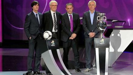 Die Trainer der Gruppe B, Joachim Löw (l.) der Däne Morton Olson (2.v.l.), der Portugiese Paulo Bento und der Niederländer Bert van Marwijk (r.) posieren mit dem offiziellen Spielball "Tango 12" und dem EM-Pokal. So richtig glücklich ob der zugelosten Gegner sehen sie nicht aus.
