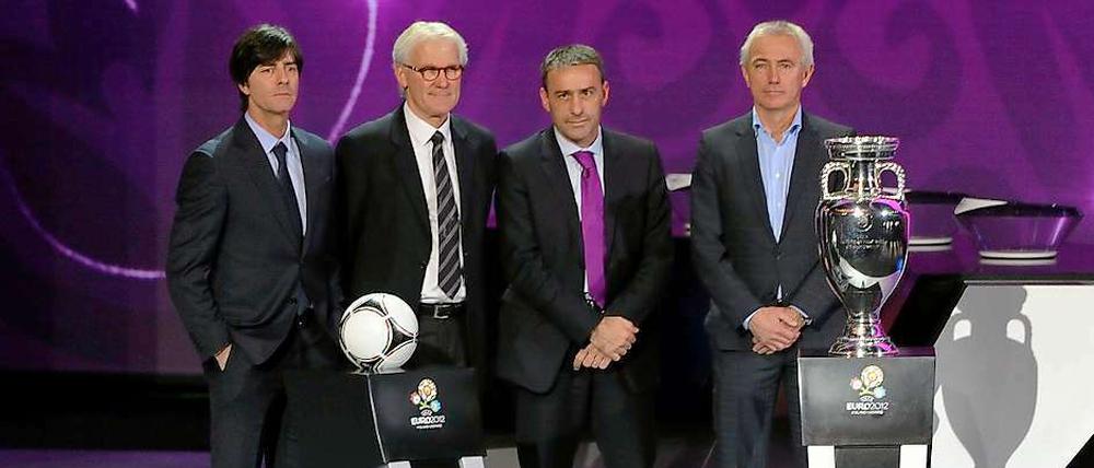 Die Trainer der Gruppe B, Joachim Löw (l.) der Däne Morton Olson (2.v.l.), der Portugiese Paulo Bento und der Niederländer Bert van Marwijk (r.) posieren mit dem offiziellen Spielball "Tango 12" und dem EM-Pokal. So richtig glücklich ob der zugelosten Gegner sehen sie nicht aus.