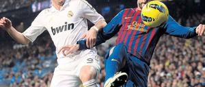 Raus aus der Illegalität, rauf aufs Trikot. Private Wettanbieter wie Bwin könnten künftig nicht nur auf den Hemden von Real Madrid (hier Karim Benzema gegen Barcelonas Gerard Piqué), sondern auch in der Bundesliga werben. Foto: Reuters