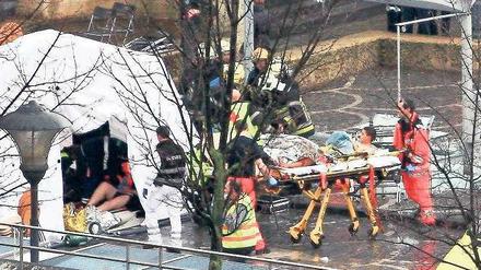 In Sicherheit. Retter bergen Verletzte auf dem Saint-Lambert-Platz. Foto: Reuters