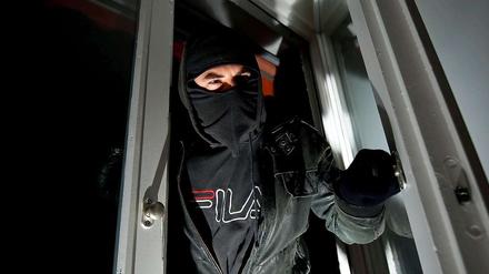 Ein Einbrecher steigt in ein Fenster ein. Wer sein Eigentum sichert, kann diese Art der Kriminalität eindämmen - doch auch die Polizei will wieder mehr Zivilfahnder auf Einbrecher ansetzen.