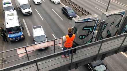 Klimaaktivist auf einer Schilderbrücke der Berliner Stadtautobahn.