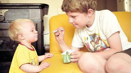 Bruder betreut Schwester. Wenn der Altersunterschied zwischen Geschwistern größer ist, übernehmen ältere Kinder eher Fürsorgepflichten. Sehr junge Eltern bringen oft schnell hintereinander ihre Kinder auf die Welt. Foto: Caro/ Aufschlager