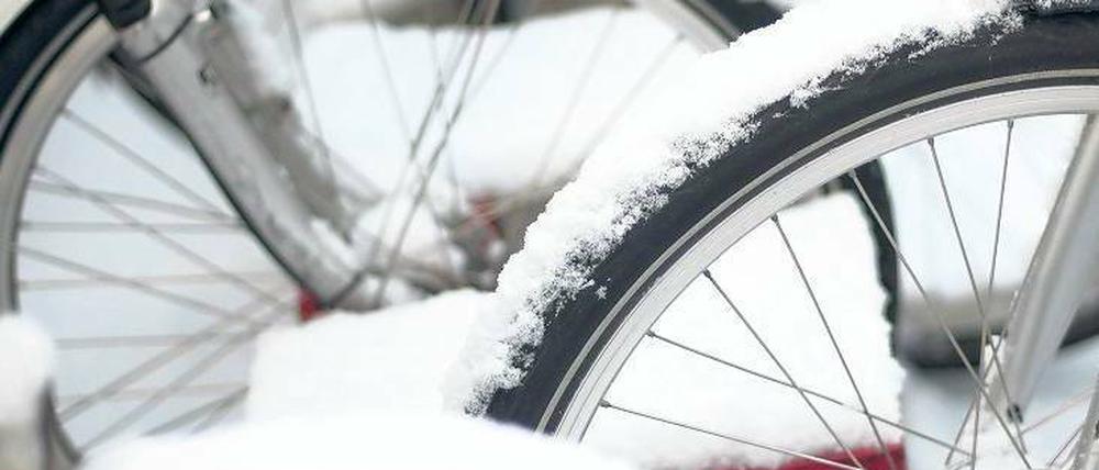 Dauerparker. Fahrradfahrern macht der Winter es besonders schwer. Zum eisigen Fahrtwind kommt nun auch noch Schnee. Und das soll erst mal so bleiben. Foto: AFP