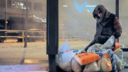 Heimat Haltestelle, wenigstens ein bisschen geschützt: Ein Obdachloser sitzt an einer Bushaltestelle. In Berlin sind immer mehr Wohnungslose auf Hilfe angewiesen. Sie brauchen Essen, Kleidung – und auch die Zuwendung Ehrenamtlicher tut gut. 