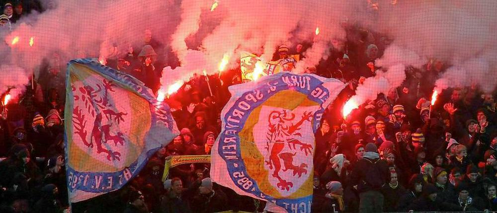 Braunschweiger Fans machen Feuer im eiskalten Frankfurter Stadion.