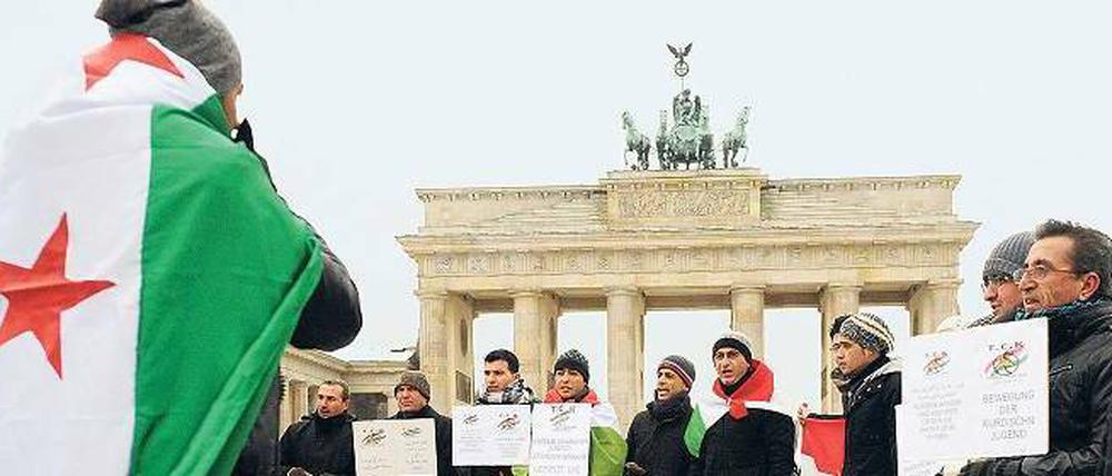 Protest vorm Tor. In Deutschland lebende Syrer demonstrierten am vergangenen Sonntag in Berlin gegen die Gewalttaten des Assad-Regimes. Foto: Maurizio Gambarini/dpa