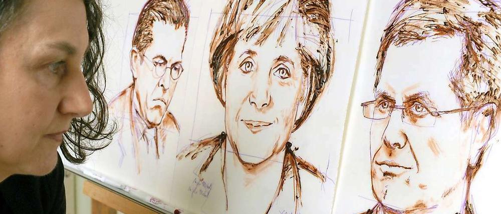 Bundeskanzlerin Angela Merkel gezeichnet von einer Schokoladenkünstlerin - inmitten der beiden Krisenpolitiker. Der eine, Karl-Theodor zu Guttenberg ist schon weg, den anderen Bundespräsident Christian Wulff verteidigt sie noch.