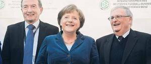 Bald-Präsident, Kanzlerin, Noch-Präsident. Theo Zwanziger (r.) und sein Kollege Wolfgang Niersbach nehmen Angela Merkel gern in ihre Mitte. Foto: dpa