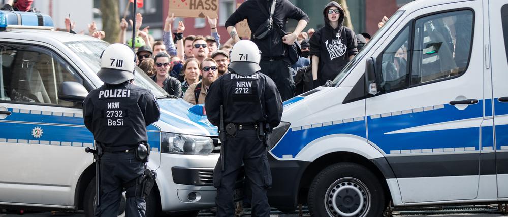 Linke Demonstranten stehen in Dortmund vor einer Polizeiabsperrung während Rechtsextremisten in der Innenstadt demonstrieren.