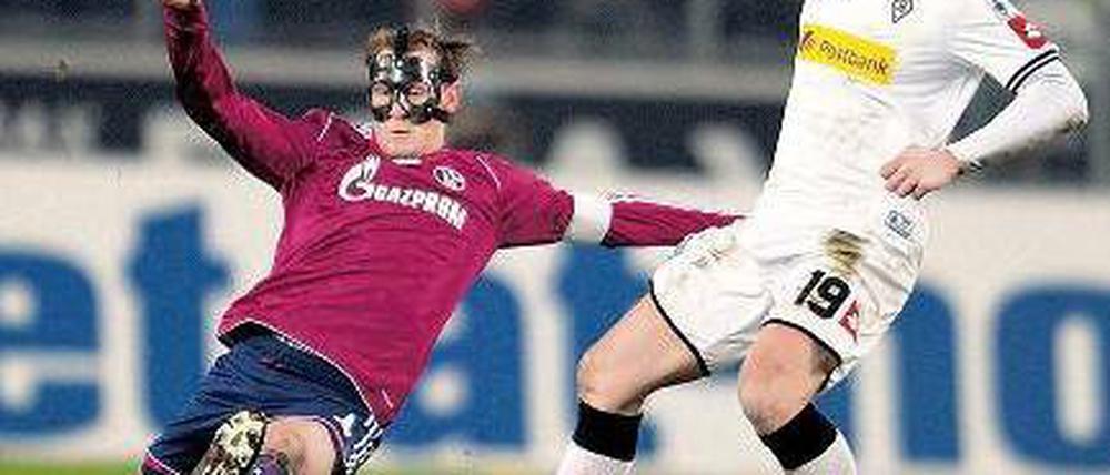 Zorro kommt zu spät. Auch der Schalker Benedikt Höwedes (l.) konnte Mike Hanke und Gladbach nicht stoppen. Foto: dpa